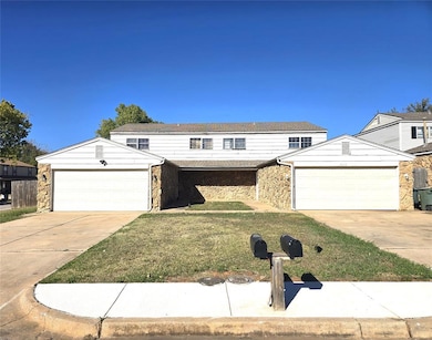 Traditional home with stone siding, driveway, a front lawn, and an attached garage