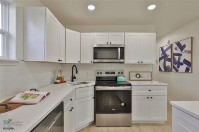 Kitchen featuring sink, white cabinets, stainless 