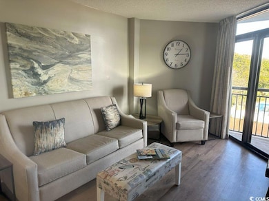 Living room featuring a textured ceiling, hardwood