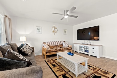 Living room with light wood-style flooring and a ceiling fan