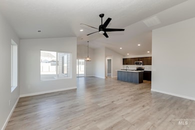 Unfurnished living room with light wood-style floors, lofted ceiling, ceiling fan, recessed lighting, and a textured ceiling