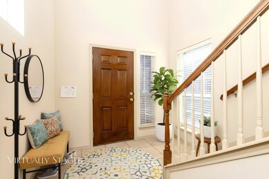 Foyer with light tile patterned flooring and stairway