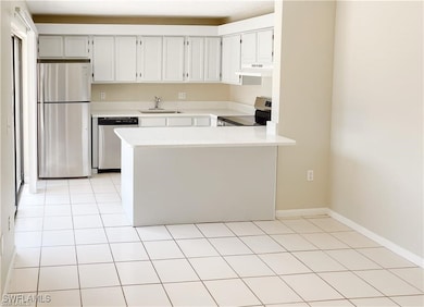 Kitchen with a sink, light countertops, a peninsul
