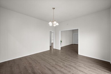 Unfurnished room featuring a chandelier and dark wood-type flooring