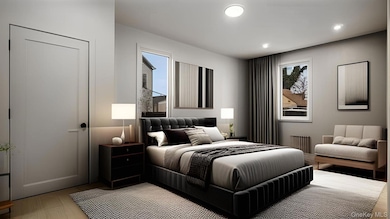 Bedroom featuring radiator, light wood finished floors, and recessed lighting