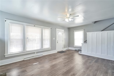 Entrance foyer with baseboard heating, wood finished floors, and ceiling fan
