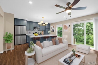 Staging option sofa back to island area. Living room with a chandelier, dark wood finished floors, recessed lighting, baseboards, and ceiling fan. Virtually staged.