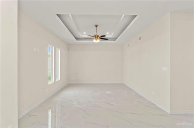 Living room with a tray ceiling and ceiling fan