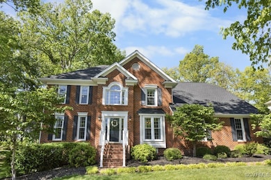 Colonial home featuring brick siding
