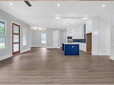 Kitchen with baseboards, open floor plan, dark woo