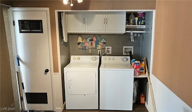 Laundry area featuring separate washer and dryer, cabinet space, and a heating unit