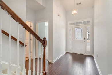 Entrance foyer with a high ceiling and dark hardwo