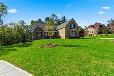 View of front of property with a front yard, stone siding, and brick siding
