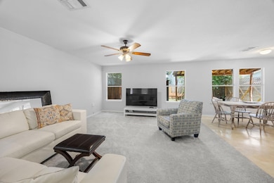 Living area with ceiling fan and baseboards