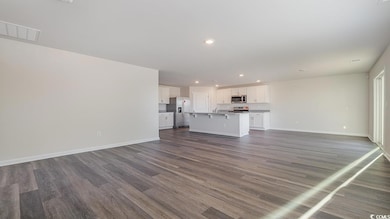Unfurnished living room featuring dark hardwood / 