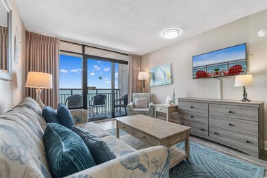 Living area with light wood-type flooring, a wall of windows, and a textured ceiling