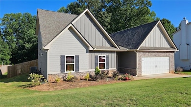 Craftsman house with board and batten siding, roof with shingles, and stone siding