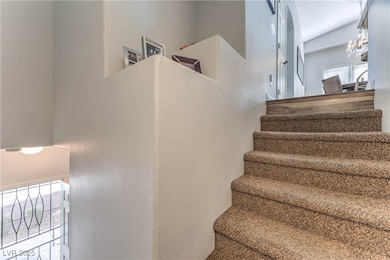Stairs featuring a chandelier and a textured wall