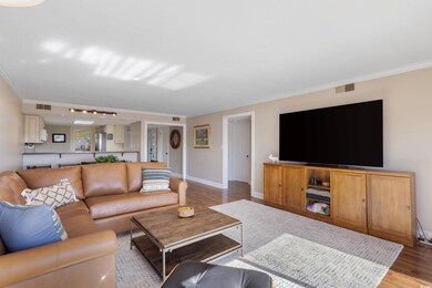 Living room with wood finished floors and ornamental molding