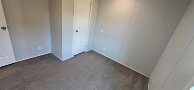 Unfurnished bedroom with dark colored carpet and 