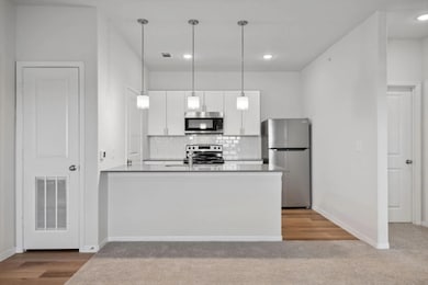 Kitchen featuring hanging light fixtures, light ha