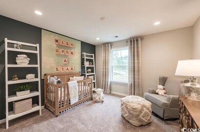 Bedroom featuring a crib, recessed lighting, carpe