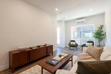 Living area with light wood-style flooring, recessed lighting, and a wall mounted AC