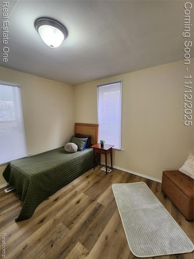 Bedroom featuring wood finished floors and baseboards