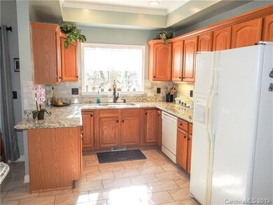 Sunny Kitchen with Tile Floor and Granite Counter 