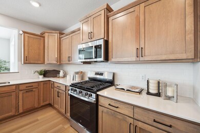 Cook in style with this charming kitchen featuring rich wood cabinets, gleaming stainless steel appliances, and sleek quartz countertops.