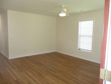Empty room featuring wood finished floors and a ceiling fan