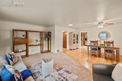 Living room featuring a ceiling fan and light carpet