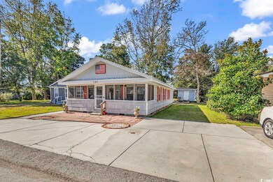 View of front of property with a shed, a front law