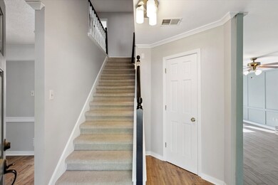 Staircase featuring ceiling fan, ornamental moldin