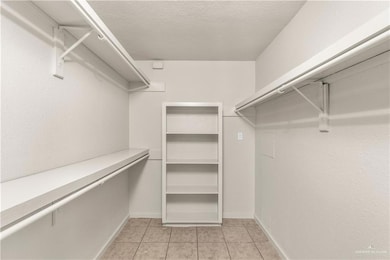 Walk in closet with light tile patterned floors