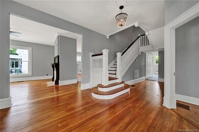 Large, formal foyer with original wood staircase. 