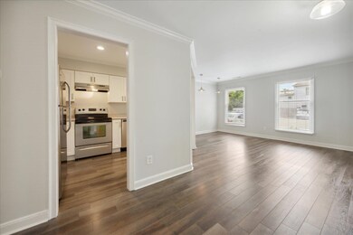 Kitchen featuring crown molding, white cabinets, d