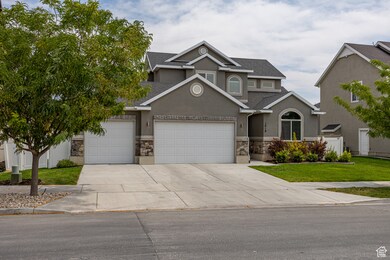 View of front of house featuring stone siding, roof with shingles, and concrete driveway