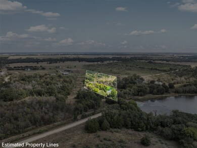 Overhead property map view illustrating the estimated boundary lines overlaid on a dense, wooded section adjacent to a body of water, with the general terrain visible in the background.
