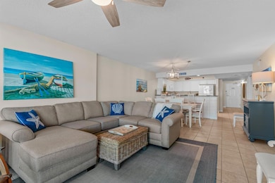 Living room featuring light tile patterned floors, ceiling fan, and a textured ceiling