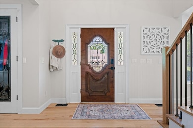 Foyer with wood finished floors, baseboards, and v