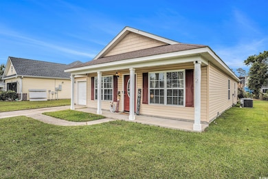 View of front of house featuring covered porch, a front yard, and roof with shingles