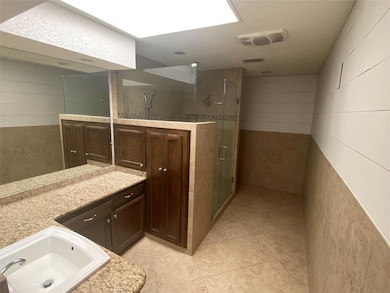 Bathroom featuring an enclosed shower, vanity, a textured ceiling, and tile floors