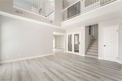 Unfurnished living room featuring a towering ceili