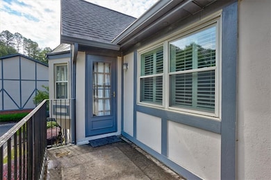 Doorway to property featuring roof with shingles and stucco siding