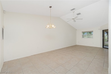 Empty room featuring a chandelier, lofted ceiling,