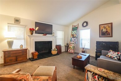 Living room with lofted ceiling, a fireplace, and