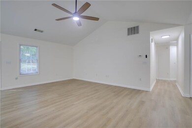 Empty room with ceiling fan, light wood-type floor