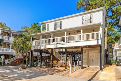 View of front facade with ceiling fan, stairway, a carport, and covered porch