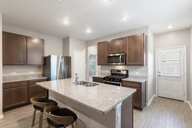 Island kitchen features granite counter tops, unde